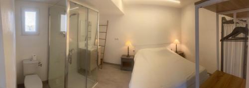 - une chambre blanche avec un lit et une douche en verre dans l'établissement "Chambre" Chez Zabou, à Carpentras