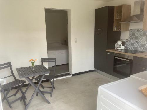 une cuisine avec une table et des chaises et une cuisine avec un évier dans l'établissement "Chambre" Chez Zabou, à Carpentras