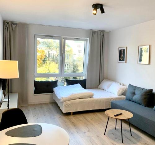 ein Wohnzimmer mit einem Sofa und einem Tisch in der Unterkunft Platon Residence Apartments in Łódź