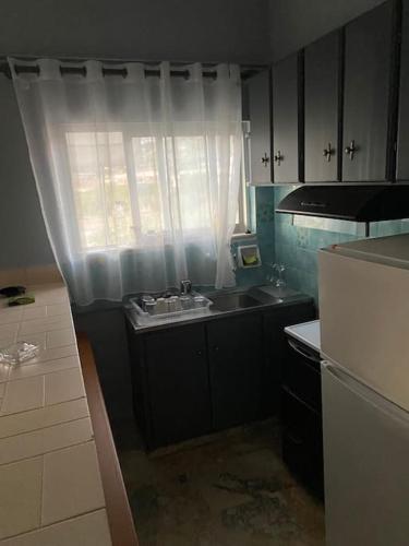 a small kitchen with a sink and a window at Akrata Studio in Akrata