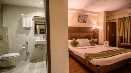 a hotel room with a bed and a shower at Vatika Inn Hotel City Center in Udaipur