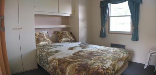 Schlafzimmer mit einem Bett und einem Fenster in der Unterkunft tuinfluiter 50 in Oisterwijk
