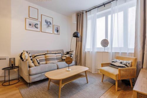 uma sala de estar com um sofá e uma mesa em Charming Apartment 6Pax in Vibrant Rue d'Hauteville em Paris