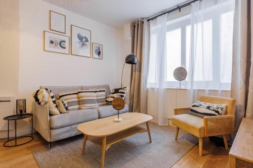 un salon avec un canapé et une table dans l'établissement Modern apartment - 2BR-6P - République, à Paris