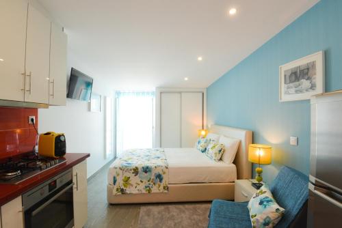 a small bedroom with a bed and a kitchen at Holidays Nazaré marginal in Nazaré