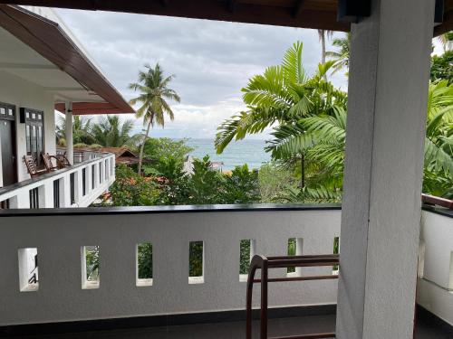 a balcony with a view of the ocean at Unawatuna Beach Bungalow - in Unawatuna