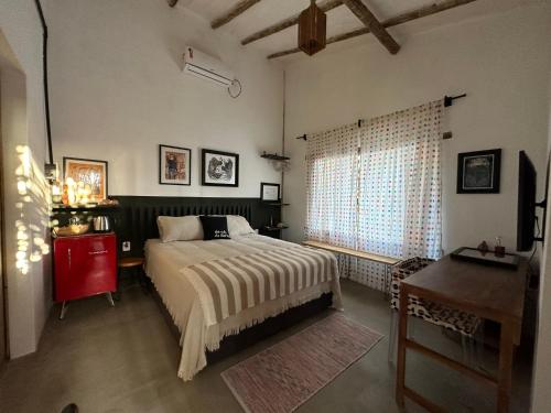 a bedroom with a bed and a desk and a window at Casa Chão in Prado