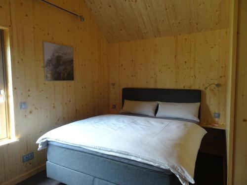 sypialnia z łóżkiem w drewnianej ścianie w obiekcie Alte Tischlerei Engelsbach w mieście Georgenthal