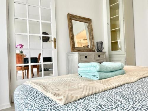 Un dormitorio con una cama con toallas azules. en Appartement 2 pièces proche Enghien-Les-Bains, en Soisy-sous-Montmorency