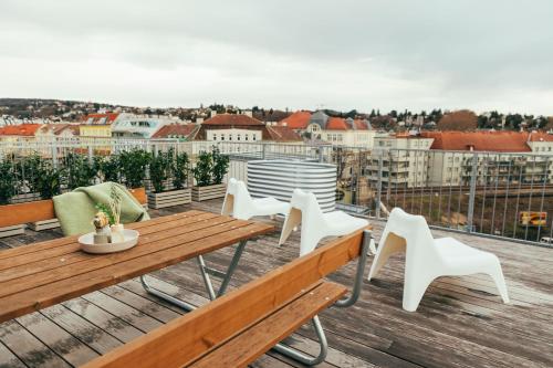 a balcony with a wooden table and white chairs at Large Apartments - Great for Groups - with Balcony or Terrace in Vienna