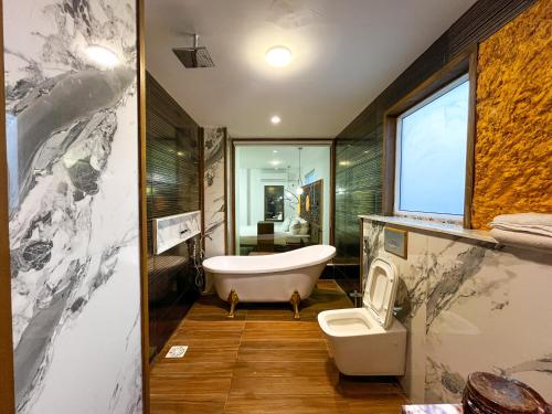 a bathroom with a tub and a toilet at Hotel Crown Inn in Karachi