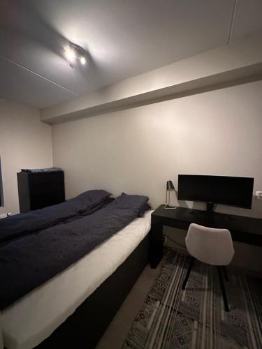 een slaapkamer met een bed en een bureau met een computer bij Penthouse, Lerkendal, NTNU, free parking in Trondheim
