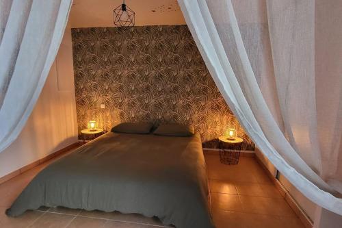 een slaapkamer met een bed met 2 lampen en gordijnen bij Casa Marcelli 4 in Porto-Vecchio