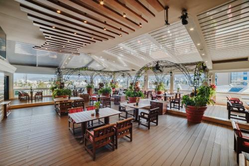 a restaurant with tables and chairs and potted plants at The Arkin Colony Hotel in Kérynia
