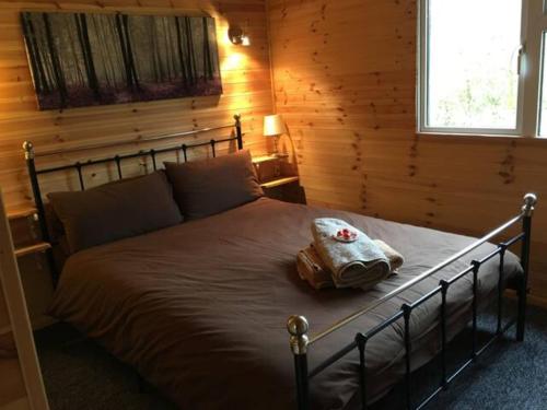 萊奇萊德的住宿－Riverwood Lodges，一间卧室配有一张床,床上有毛巾