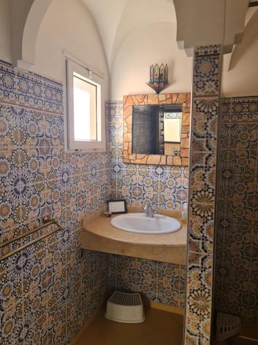 La salle de bains est pourvue d'un lavabo et d'un miroir. dans l'établissement Riad BAB ALMADINA, à Marrakech