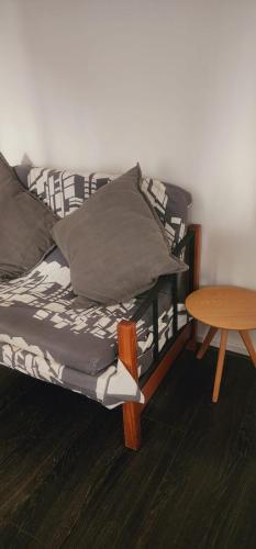 a bed with pillows and a table in a room at Departamento 2d1b Puerto Varas in Puerto Varas