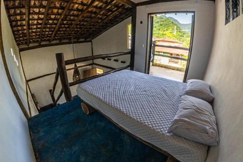 a bedroom with a bed in a room with a window at Duplex Sol in Maresias