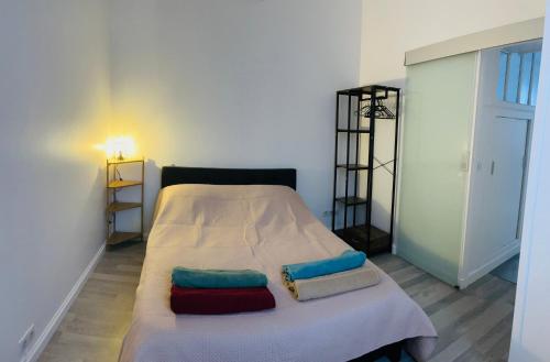 ein Schlafzimmer mit einem Bett mit zwei Kissen darauf in der Unterkunft Le Sannoisien - Joli appt à proximité de Paris in Sannois