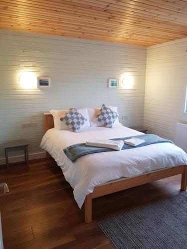 Bett in einem Zimmer mit zwei Kissen darauf in der Unterkunft Crag Na Cor Log Cabin in Culdaff