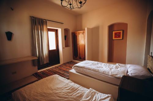 a bedroom with two beds and a window at Tzila Bahariya in Az Zaytūn
