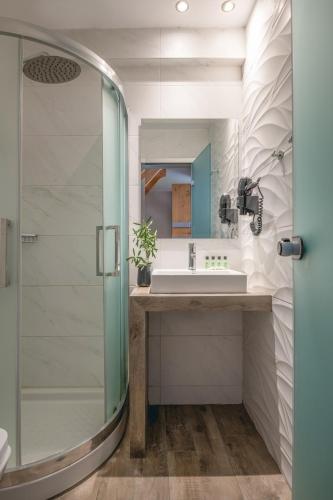 a bathroom with a sink and a glass shower at Vrahakia in Sarti