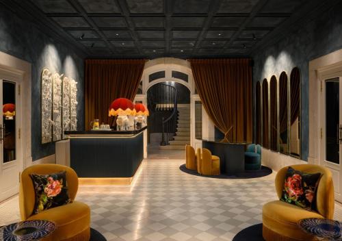 a lobby with yellow chairs and a hair salon at Montebelo Vista Alegre Lisboa Chiado Hotel in Lisbon