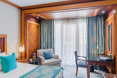 a bedroom with a bed and a desk and a chair at The Arkin Colony Hotel in Kérynia