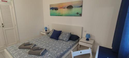 Dormitorio pequeño con cama con almohadas azules en Apartamento Oasis Azul, vista oceano. en Puerto del Carmen