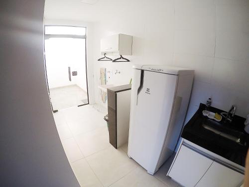 a small kitchen with a white refrigerator in it at Condomínio Vista Nobre in Varginha