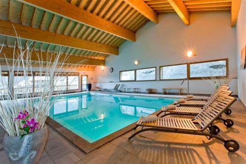 una piscina con 2 tumbonas en una casa en Orelle 3 Vallées - 2 pièces 6 personnes, en Orelle