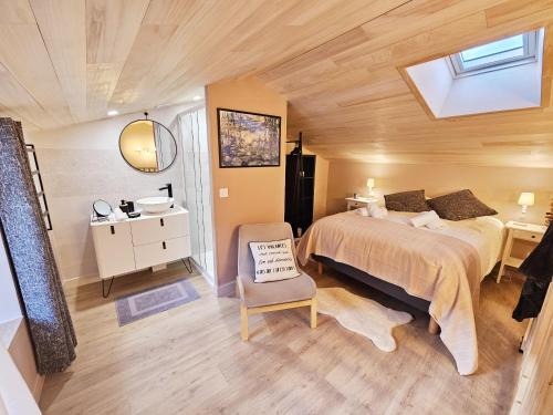 une chambre avec un lit et une chaise dedans dans l'établissement Côté cour chaleureuse maison, à LʼIsle-dʼEspagnac