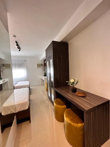 een kamer met een tafel en twee krukken en een slaapkamer bij Hotel living,The Persimmon Suites 2-4pax (1804) in Cebu City