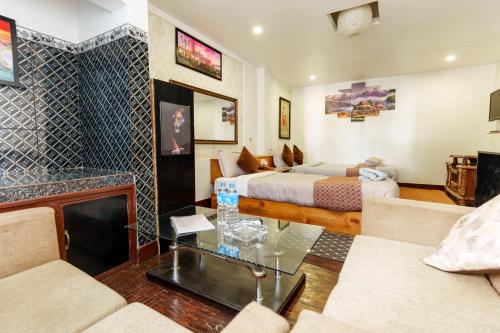 ein Hotelzimmer mit einem Bett und einem Wohnzimmer in der Unterkunft Hotel Shree Tara in Kathmandu