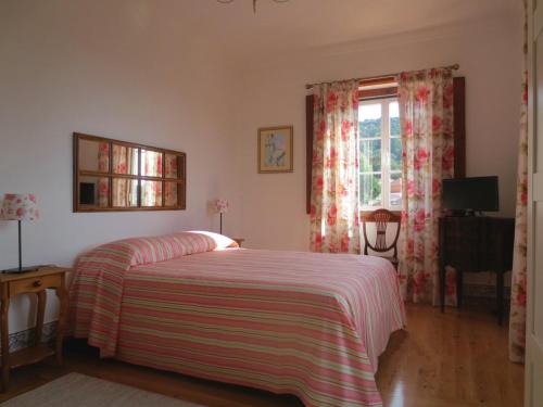 1 dormitorio con 1 cama con manta a rayas y ventana en Casa da Villa 1A, en Sintra