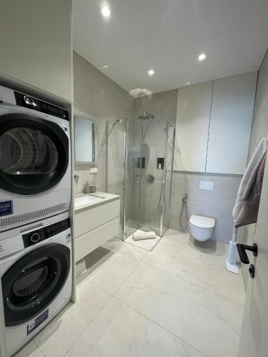 a bathroom with a washer and dryer in it at Balance in Nida in Nida