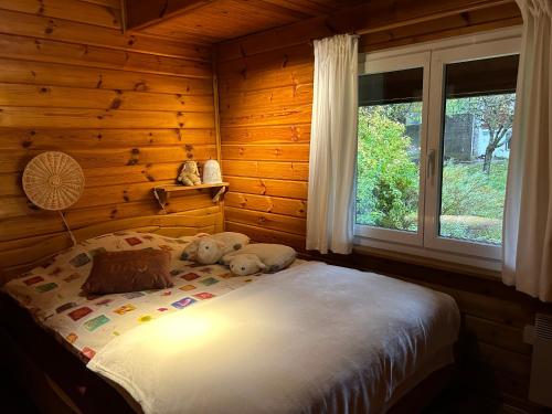 Un dormitorio con una cama con dos ositos de peluche. en Jolie chambre dans chalet, en Le Vaud