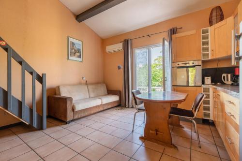 a kitchen and living room with a table and a couch at Domaine De La Bégude in Fayence