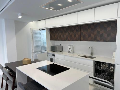 Una cocina con gabinetes blancos y encimera. en SMILE CAVANA APARTMENTS, en Nerja
