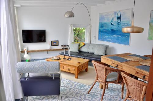 uma sala de estar com um sofá e uma mesa em Duinland 27 em Sint Maartensvlotbrug