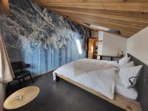 ein Schlafzimmer mit einem Bett und einer Wand mit einem Wandbild in der Unterkunft Hôtel-Restaurant Le Cochon Rose in La Sagne