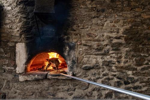 a brick oven with a fire in it at Manoir majestueux à Satillieu avec piscine privée in Satillieu