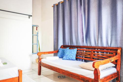 a bedroom with a wooden bed with blue pillows at Pousada Aconchego Recanto Canto Do Mar in Bairro da Enseada