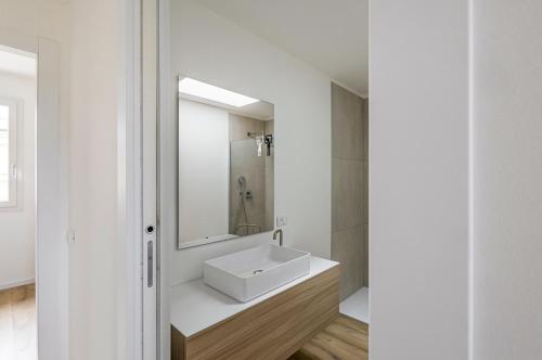 ein weißes Badezimmer mit einem Waschbecken und einem Spiegel in der Unterkunft Diana - Sirio- Aura Montegrotto Terme Lovely Apartments! in Montegrotto Terme