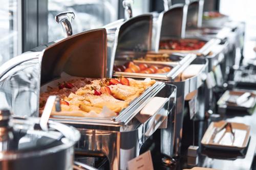 eine Buffet-Linie mit Tabletts mit Speisen zur Verfügung in der Unterkunft Dune Beach Resort - A in Mielno