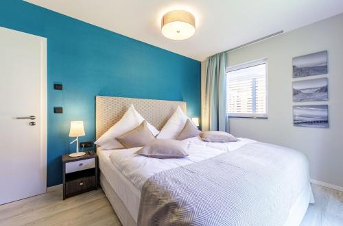 um quarto com uma cama grande e uma parede azul em Seeluft an der Ostsee em Wustrow