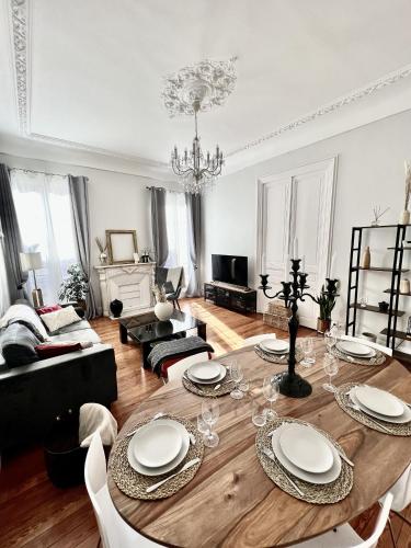 d'un salon avec une table en bois et des plaques blanches. dans l'établissement Superbe Appartement de 105 m2, hyper centre avec Terrasse, parking, à 5 min de la mer, à Nice