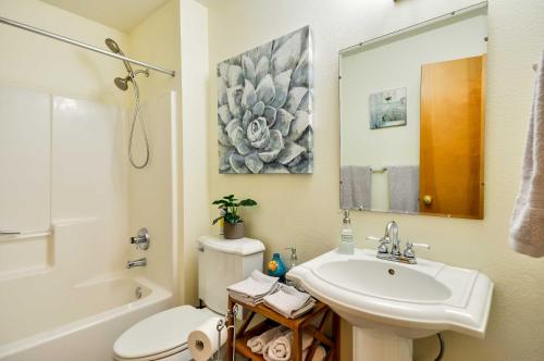 a bathroom with a sink and a toilet and a mirror at Milwaukie Home with Covered Porch Dogs Welcome! in Milwaukie