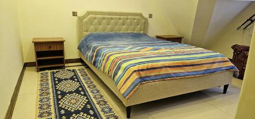 Un dormitorio con una cama con una manta a rayas. en Diplomatic Short Stay in Gigiri en Nairobi