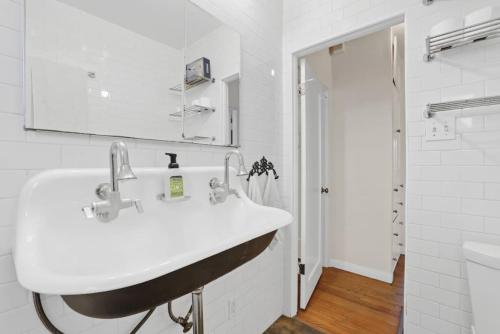 a white bathroom with a sink and a mirror at Urban Artist Retreat in Silverlake in Glendale